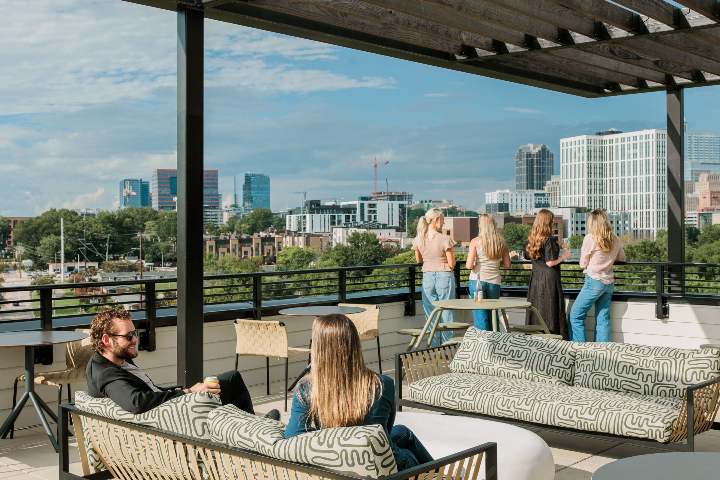 people talking on roof top lounge. aerial view of downtown raleigh.